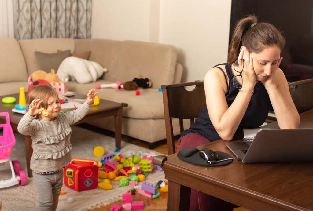 Kız, yerde oyuncakları olan bir odada ağlıyor ve yorgun annesinin onu almasını bekliyor.
